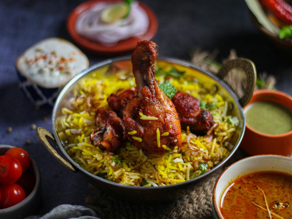 Flavorful chicken biryani with herbs and spices served in a traditional brass bowl, capturing the essence of Indian cuisine.